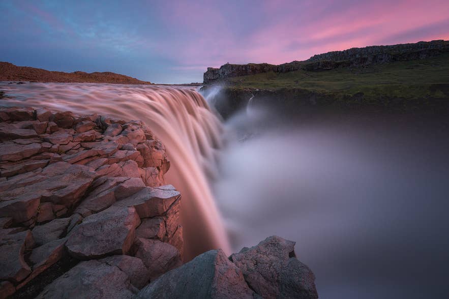 La cascade de Dettifoss se précipitant sur des falaises rocheuses au coucher du soleil en Islande.