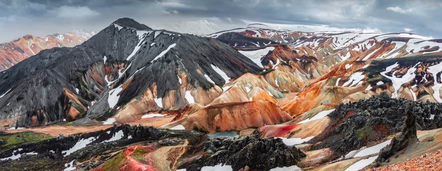 Kleurrijke ryolietbergen en sneeuwvelden vormen een levendig landschap in Landmannalaugar.