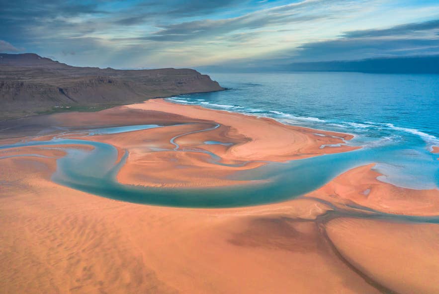 Rauðisandur rood zandstrand in de Westfjorden van IJsland met kronkelende getijdenstromen en Atlantische kustlijn.
