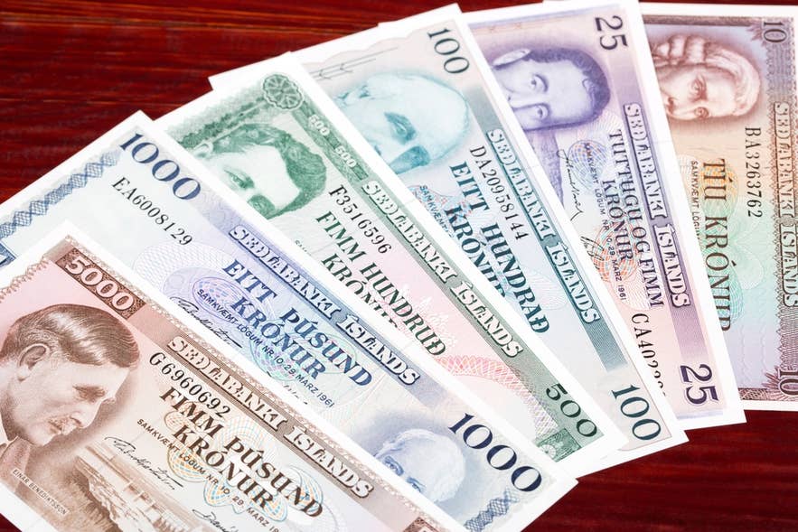 Auf einem Tisch liegen alte isländische Kronen-Banknoten, die historische Währungsformen Islands zeigen.