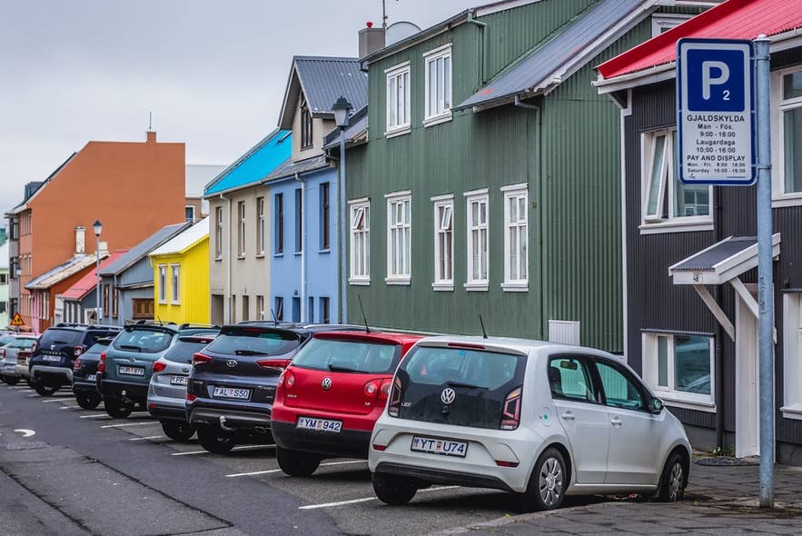 Ein Straßenparkplatz in Island mit einem Bezahlschild zeigt, wie Besucher die Parkgebühren bezahlen können.