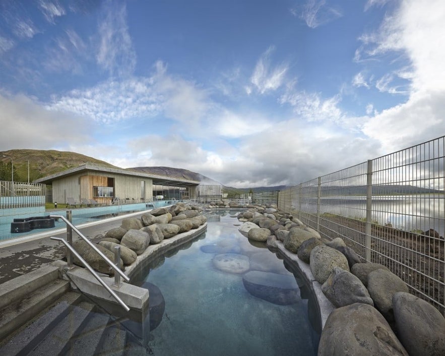Outdoor geothermal pool at Fontana Spa in Iceland, featuring natural stone-lined hot springs.