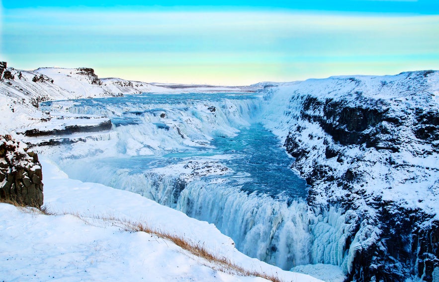 Gullfoss-Wasserfall im Winter mit vereisten Klippen und schneebedeckter Landschaft am Goldenen Kreis Islands.