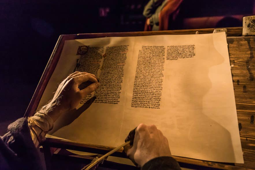 A sculpture posed as if writing on a large sheet of paper at the Saga Museum in Reykjavik, Iceland.