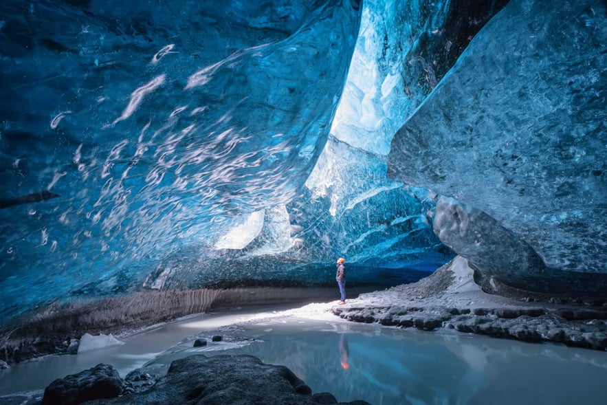 Person exploring Vatnajokull Ice Cave, one of the unique experiences in Iceland.