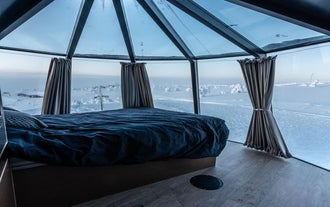 Your floating Aurora Hut has modern amenities, such as a cozy double bed, and boasts incredible views through the glass windows.