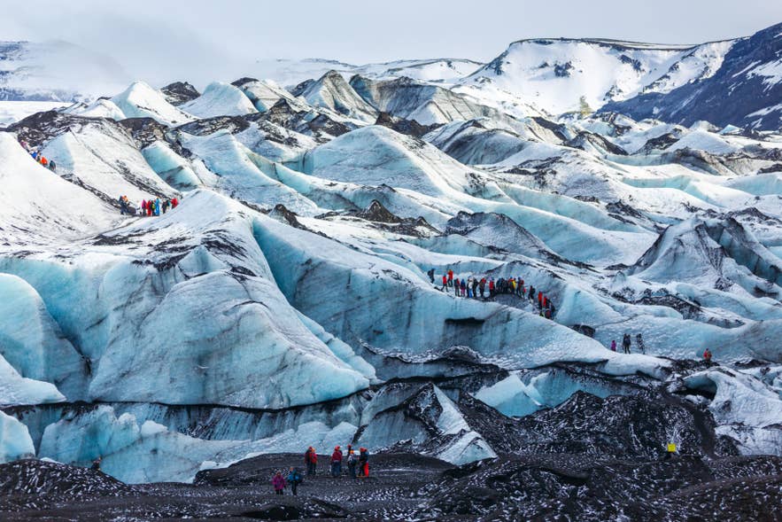 游客在索尔黑马冰川(Solheimajokull Glacier)徒步，这是冰岛最独特的体验之一。