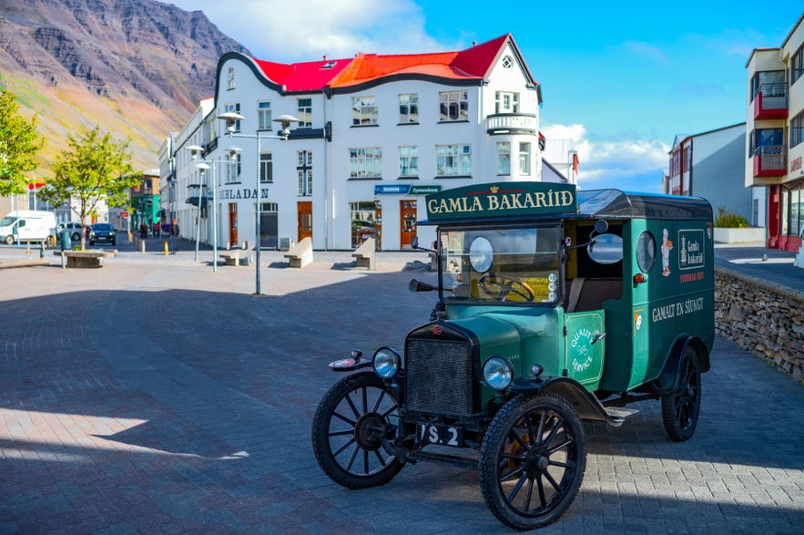 Vintage delivery car outside Gamla Bakarid Bakery in Isafjordur Town Center, Westfjords.