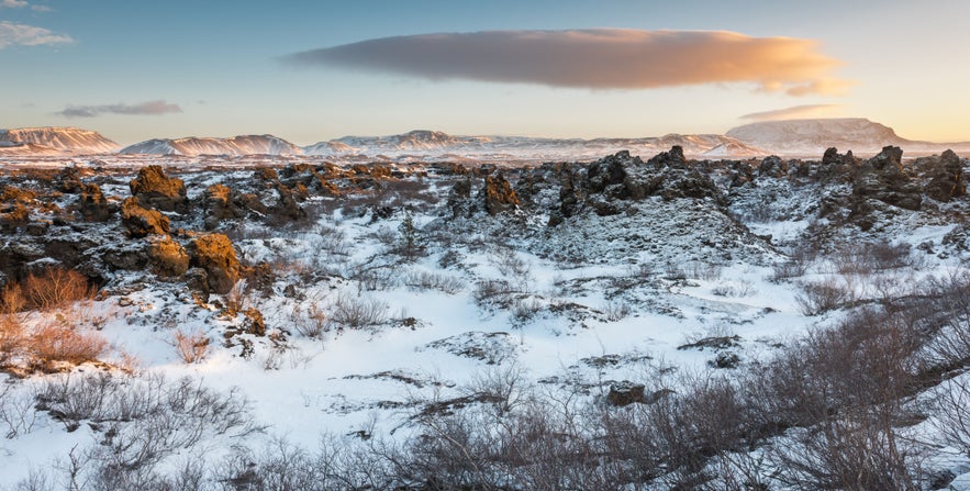 Dimmuborgir Lava Field in winter near Lake Myvatn, North Iceland, with snow-covered volcanic rock formations at sunset.