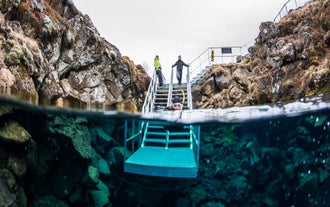 Tourist enjoying Silfra Fissure snorkeling in Iceland’s pristine volcanic water.