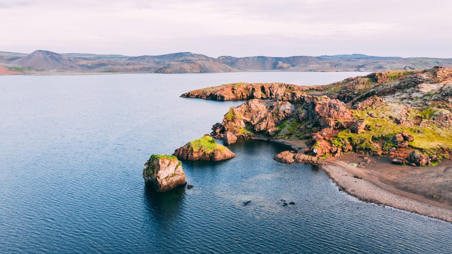 Kleifarvatn Lake on the Reykjanes Peninsula, showing volcanic cliffs, winding shoreline, and calm blue water near Reykjavik