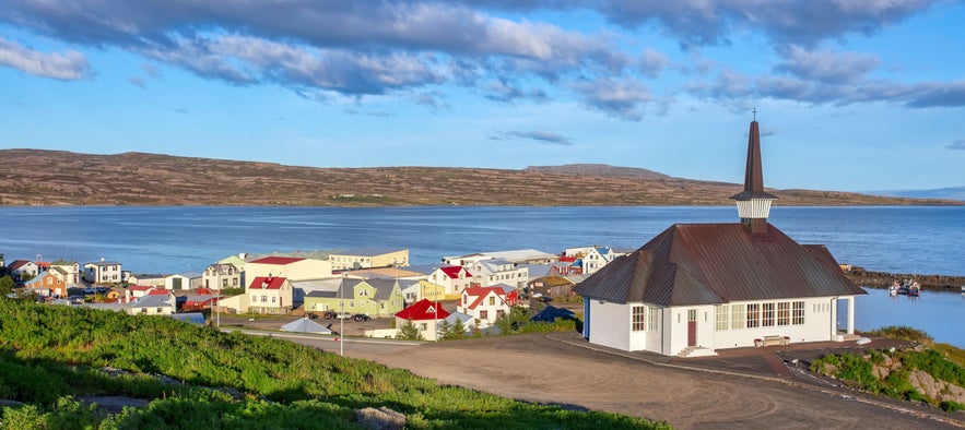 H&oacute;lmav&iacute;k village in the Westfjords of Iceland, with colorful houses, coastal harbor, and church overlooking Steingr&iacute;msfj&ouml;r&eth;ur bay