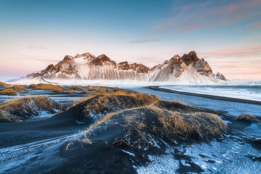 Snowy ground leads to Vestrahorn Mountain in Southeast Iceland.