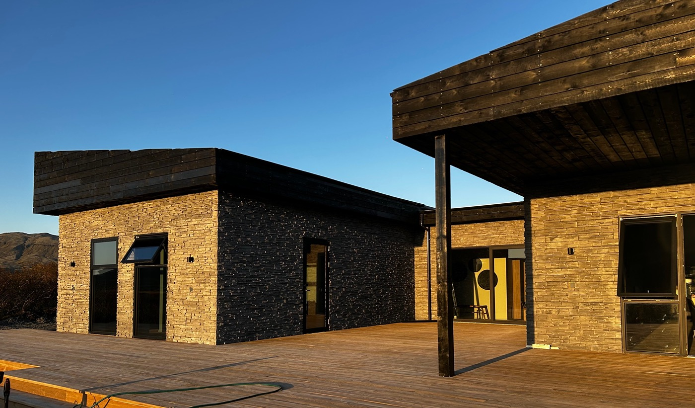 Spacious wooden deck with built-in hot tub at Golden Circle Luxury Villa in Iceland.