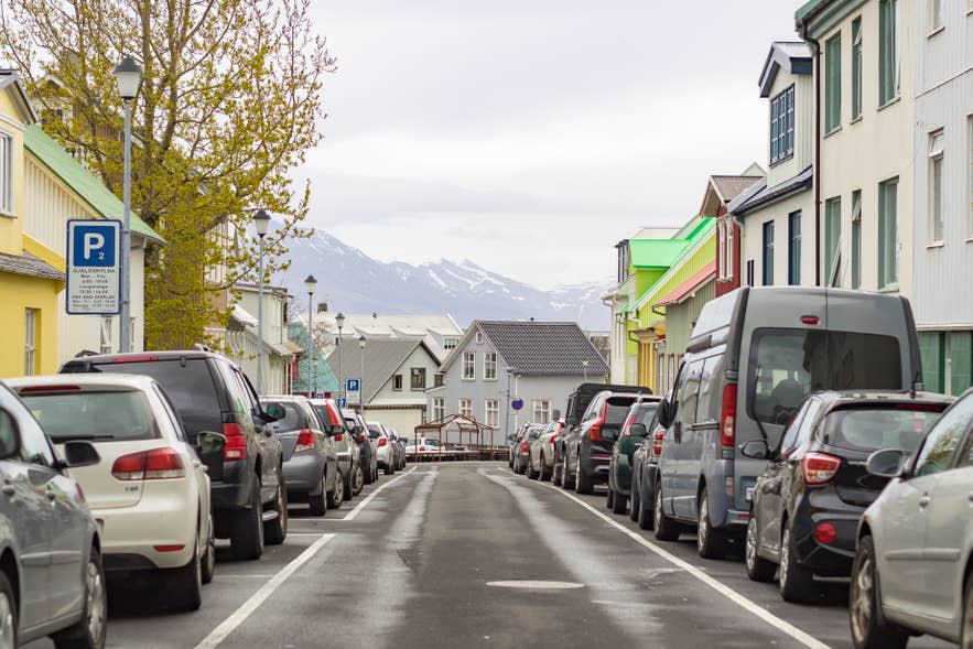 Aparcamiento en un barrio de Reikiavik con edificios coloridos y vistas al paisaje islandés. Aparcamiento en un barrio de Reikiavik con edificios coloridos y vistas al paisaje islandés.