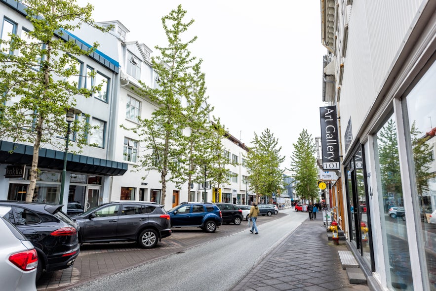 Street parking in Reykjavik near Laugavegur with shops, art galleries, and parked cars in downtown Iceland.