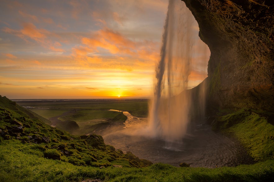 Seljalandsfoss waterfall as the midnight sun shines one