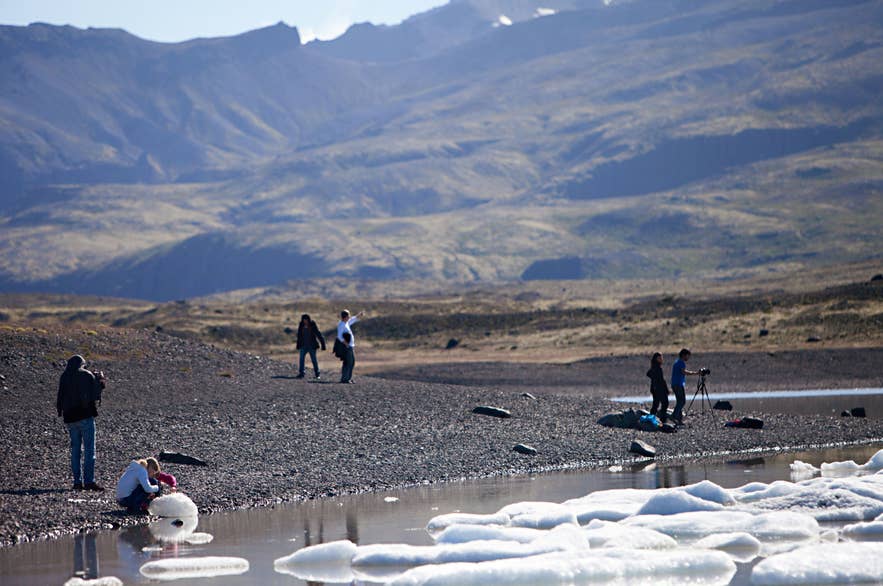 Menschen fotografieren Eisberge an der Fjallsarlon-Lagune.