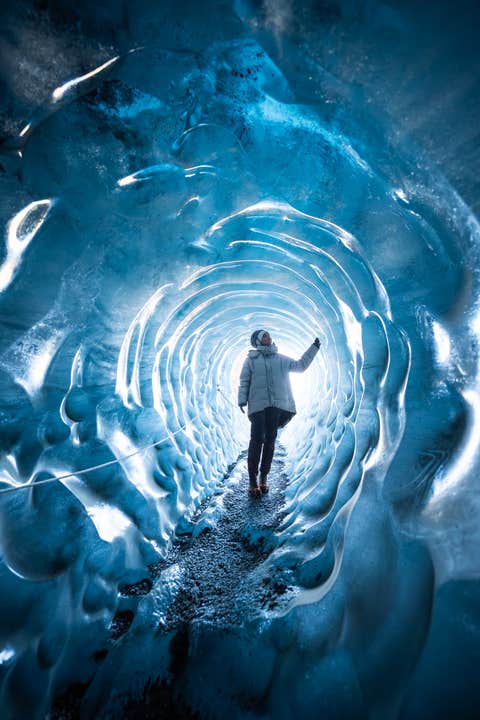 Een bezoeker die een ijsgrot verkent in Katla, gelegen aan de zuidkust van IJsland.