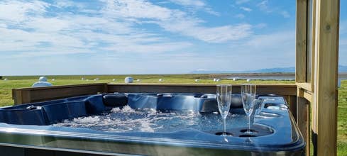 Private outdoor hot tub at Hitarneskot Accommodation with views over the surrounding landscape.