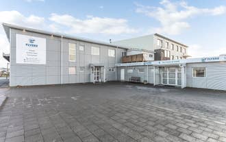 The exterior of Flyers Airport Hotel showing a one-floor blue building.