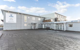The exterior of Flyers Airport Hotel showing a one-floor blue building.