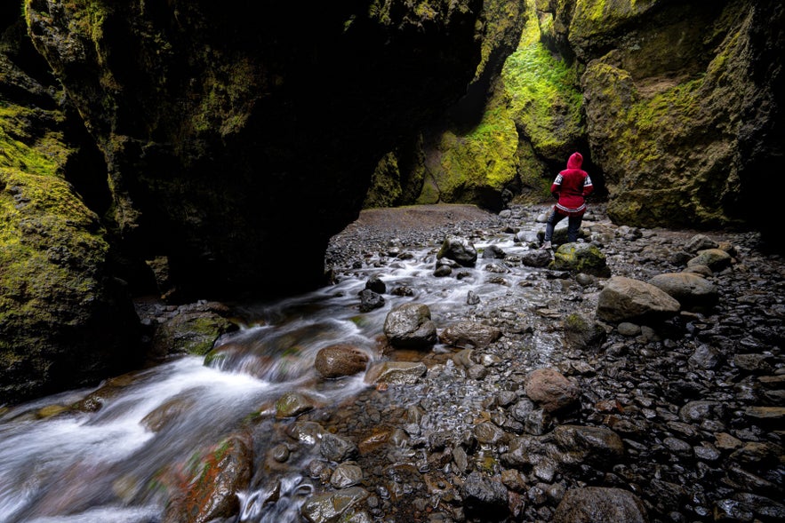 ช่องเขา Nauthusagil ใกล้ Hvolsvollur ทางตอนใต้ของไอซ์แลนด์ ช่องเขาแคบผนังมอสส์ ลำธาร และนักเดินป่าริมชายฝั่งใต้