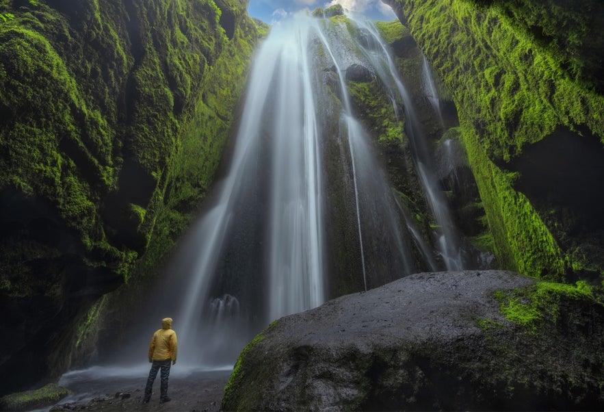 Gljufrabui Waterfall near Hvolsvollur, South Iceland, mossy canyon beside Seljalandsfoss with visitor inside.