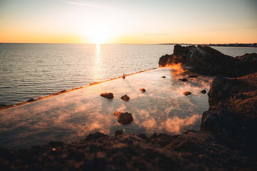 Sky Lagoon in Iceland at sunset, with warm geothermal waters and colorful sky reflections.