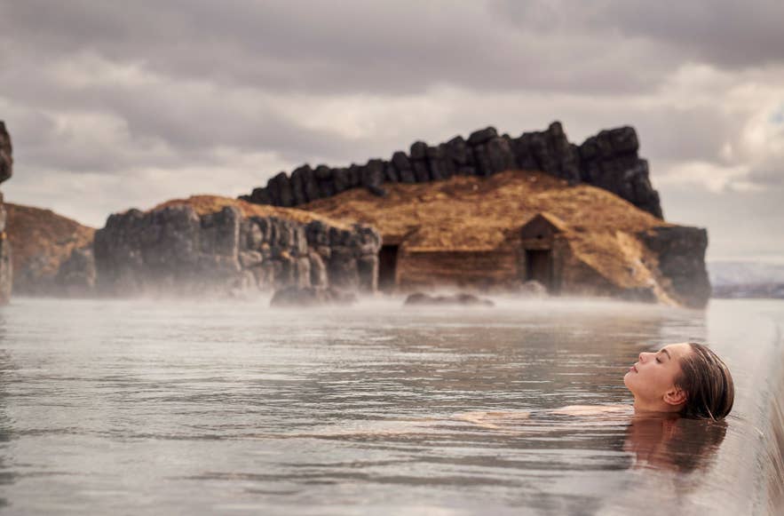 Женщина отдыхает в Sky Lagoon, погружённая в тёплую воду.
