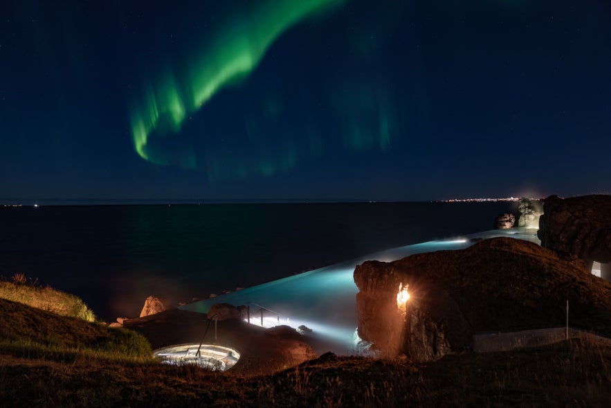 Sky Lagoon in Iceland with the northern lights over the geothermal pools.