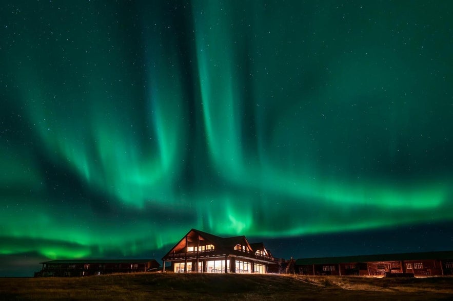 Green northern lights glow over Hotel Ranga in Hella, Iceland.