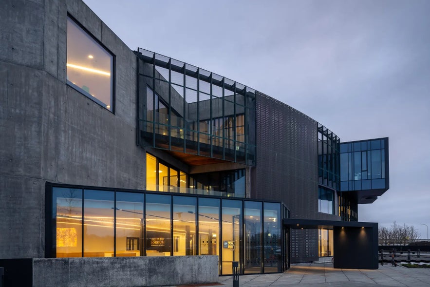 Modern exterior of the World in Words building with large windows and illuminated interior spaces. Modern exterior of the World in Words building with large windows and illuminated interior spaces.