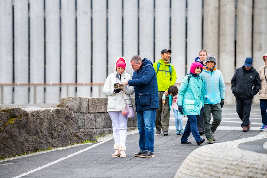 冬季人们穿着厚衣服，在雷克雅未克彩虹街Skolavordustigur附近步行。