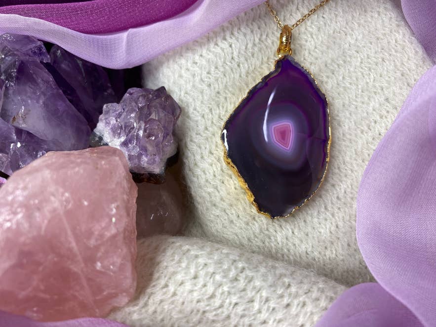 Purple agate slice pendant necklace styled with crystals, photographed for Skolavordustigur Rainbow Street shopping and local design.