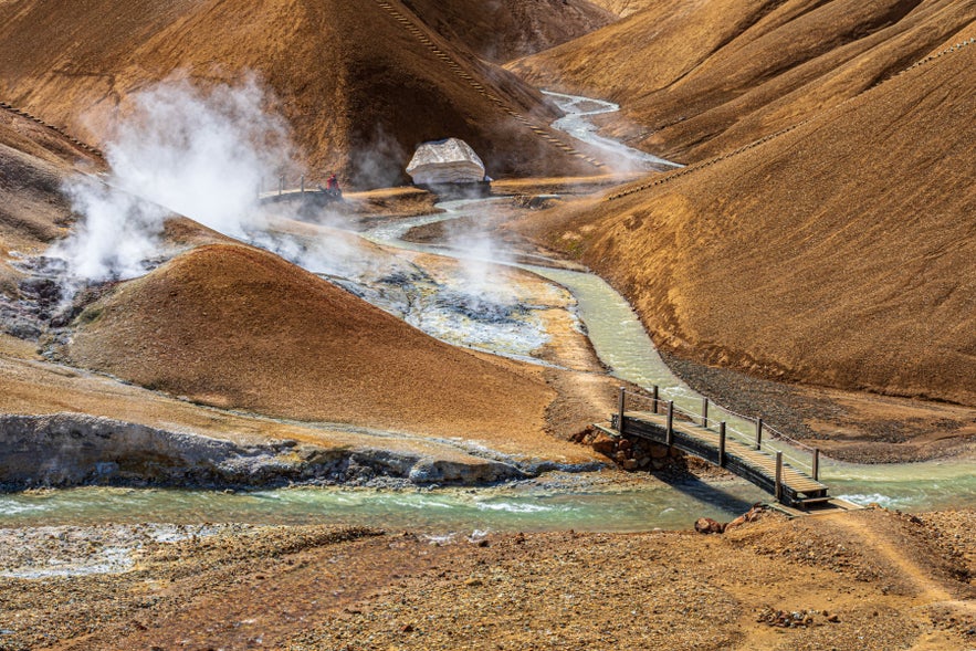 Hveradalir Geothermal Valley in Kerlingarfjoll, Iceland Highlands, with steaming vents, footbridge, and rhyolite hills.