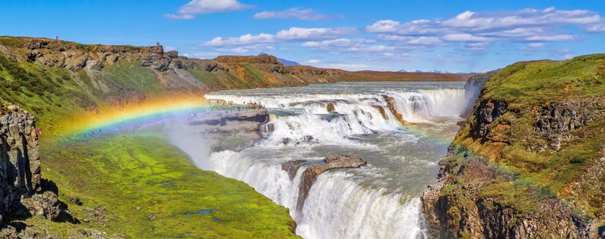 Gullfoss Waterfall in Iceland with cascading falls and a rainbow over the canyon.