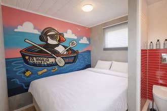 Double room at Truck Inn by Ourhotels with a full-wall mural, cozy bed, and modern interior design.