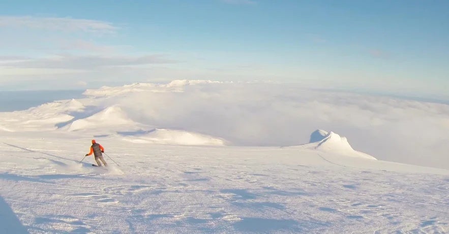 Skiing across an open mountain plateau in Iceland under clear skies.