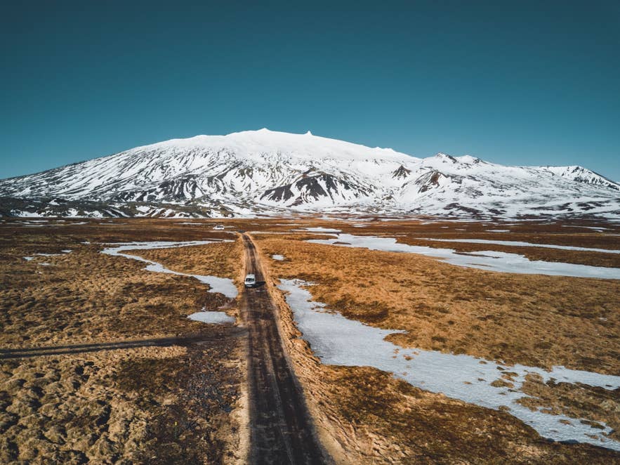 Gravel road crossing lava fields toward snow-covered Snaefellsjokull. Gravel road crossing lava fields toward snow-covered Snaefellsjokull.