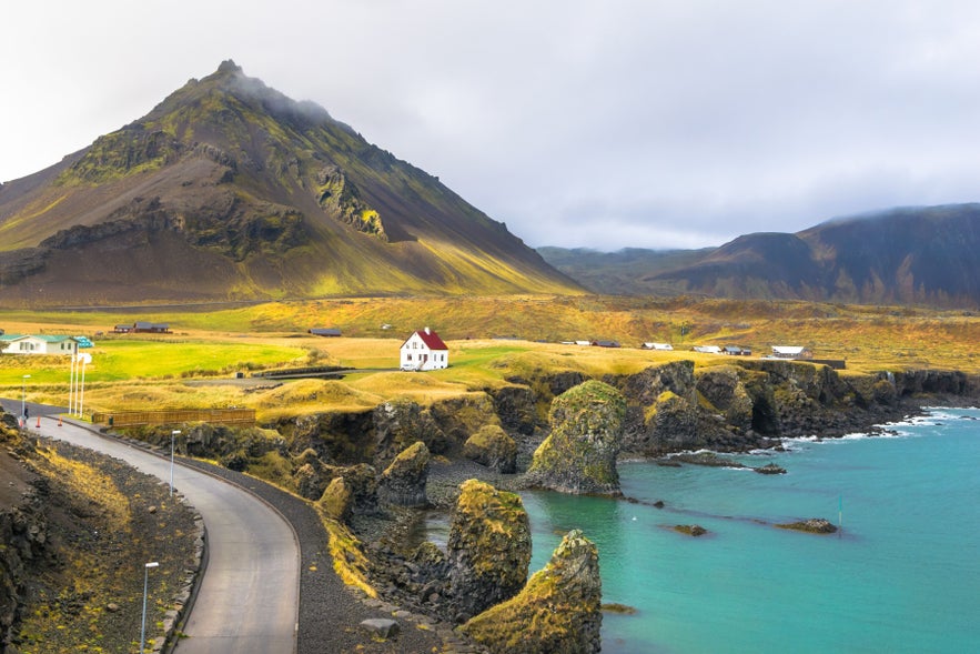 Coastal road, sea cliffs, and mountain scenery in Snaefellsjokull National Park on Iceland&rsquo;s Snaefellsnes Peninsula.