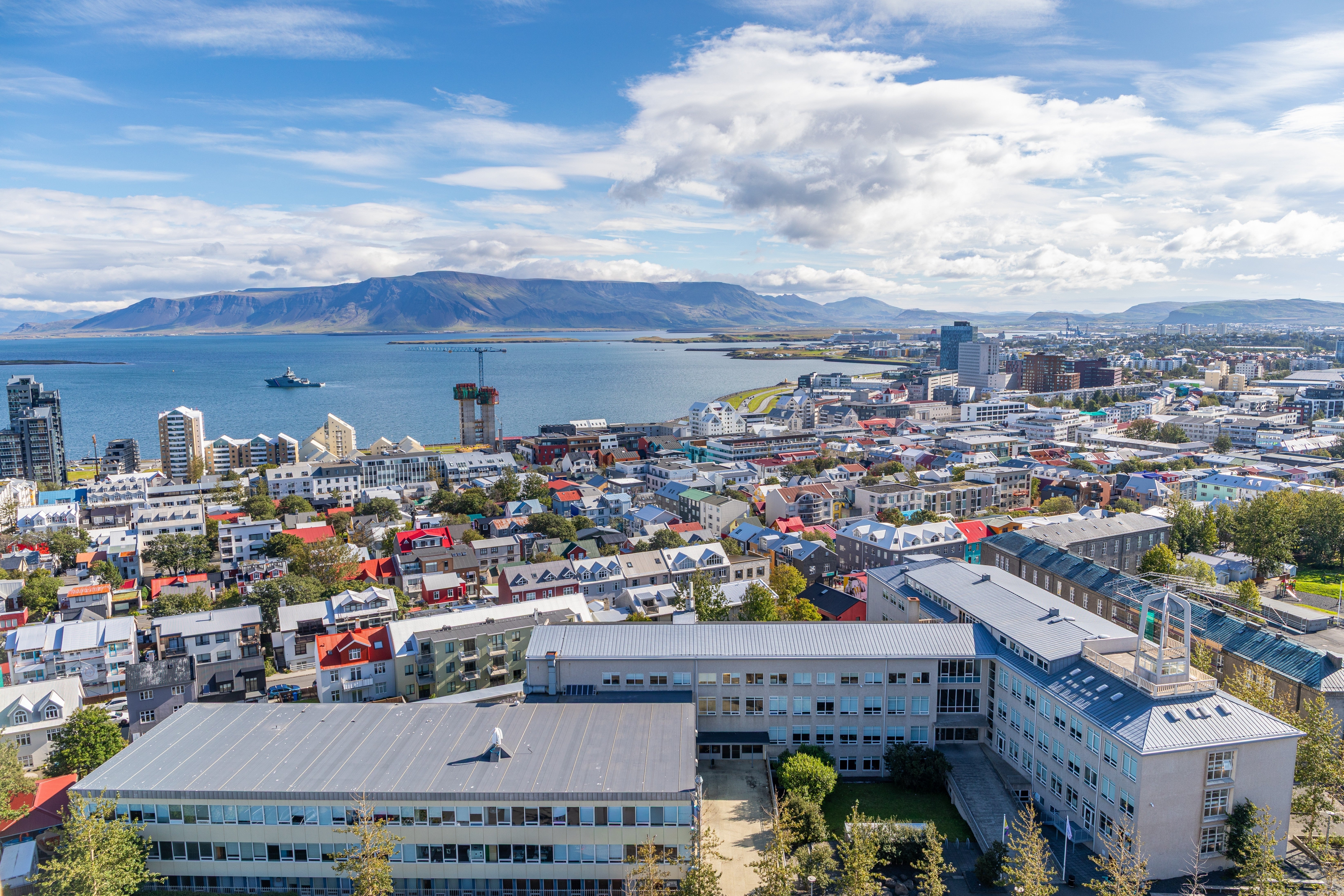 Vista panoramica di Reykjavik con i tetti colorati, la costa e le montagne circostanti in estate.