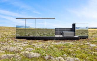 Modern Heathland Lodge exterior with glass walls overlooking open Icelandic landscape in the Golden Circle.