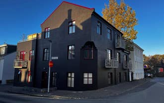 Exterior of Baldur Apartments building in Reykjavik with modern dark facade on a quiet city street