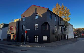 Exterior of Baldur Apartments building in Reykjavik with modern dark facade on a quiet city street