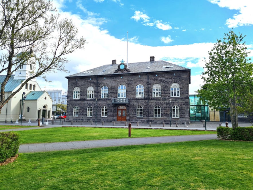 Historic Althingi Parliament in Reykjavik surrounded by trees and open green space