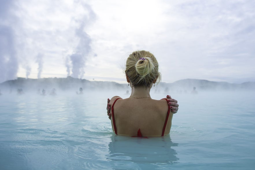 Woman bathing at Blue Lagoon Geothermal Spa near Reykjavik, illustrating nudity in Iceland and modern spa bathing culture.