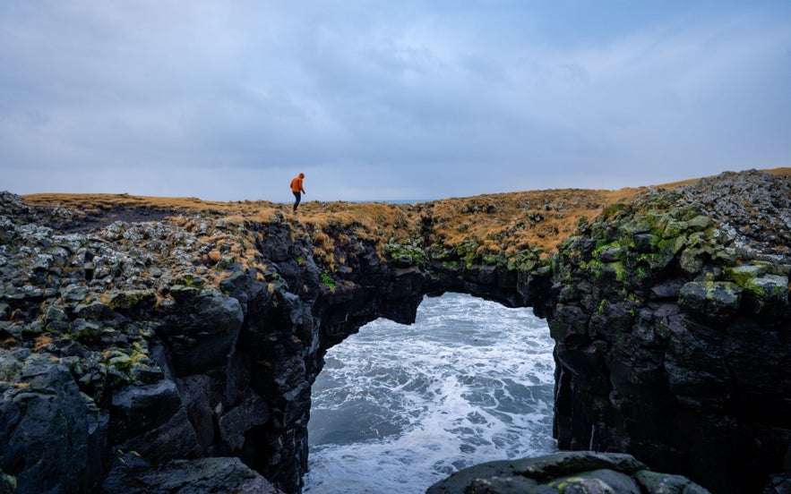 Coastal rock arch at Gatklettur near Arnarstapi in the cheapest time to go to Iceland.