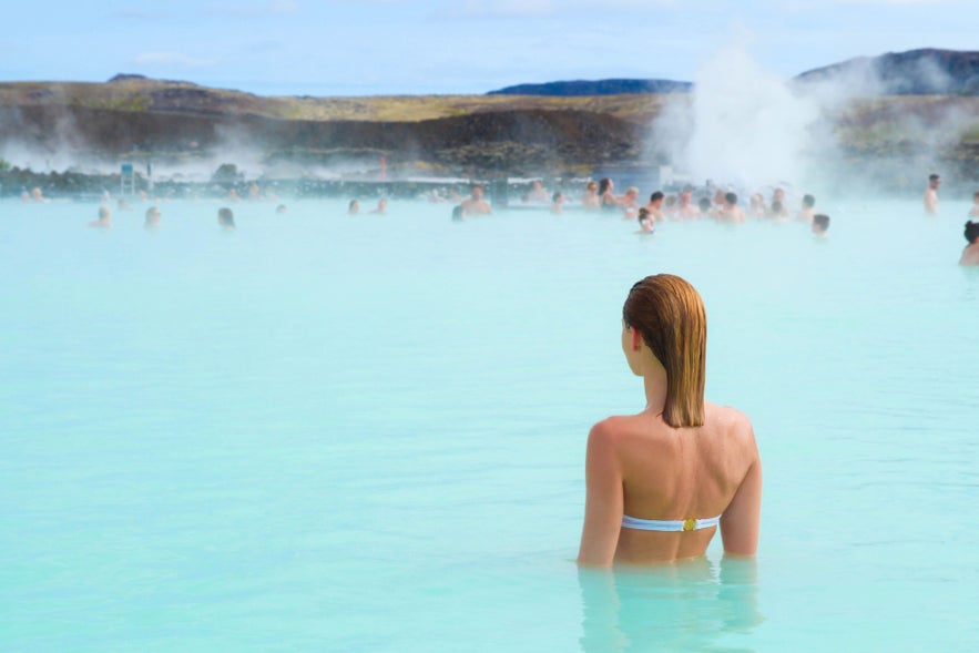 Visitor relaxing at the Blue Lagoon near Reykjavik, highlighting etiquette and planning tips for how to travel in Iceland.