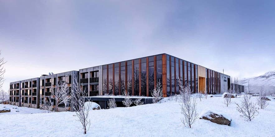 Hotel Geysir stands in a snowy landscape, surrounded by snow-covered ground.